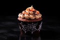 a single halloween-themed spiderweb cupcake on a black backdrop