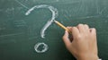 A single hand drawing a question mark on a whiteboard, prompting inquiry and problem-solving discussions Royalty Free Stock Photo