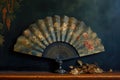 a single hand fan opened wide, placed on a painted canvas