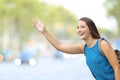 Happy woman hailing taxi cab on the street