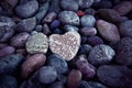 Single heart on black pebble stones