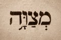 Single hebrew word Mitzvah on page of old Torah book. English translation is commandment. Hebrew script. Closeup