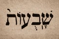 Single hebrew word Shavuot on page of old Torah book. English translation is Feast of Weeks. Jewish holiday