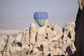 Single Hot Air Balloon rising over ancient cave dwelling in Goreme Cappadocia. Royalty Free Stock Photo