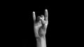 Single human hand coming up and showing Apana Mudra Yoga Hand Gesture or Mudra of Digestion isolated on black background.