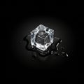A single ice cube is centered on a dark, reflective surface, surrounded by small Royalty Free Stock Photo