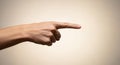 A Single Index Finger Pointing Right on a Beige Background Conveying Direction or Choice of Path Royalty Free Stock Photo