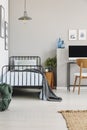 Single industrial bed with blue bedding in stylish bedroom