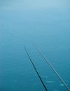 Single isolated fishing rod on blue water. Fishing on a lake in Bucharest, Romania