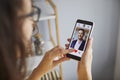 Woman looking for boyfriend, holding phone and looking at photo of man on online dating website Royalty Free Stock Photo