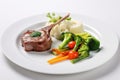 single lamb chop served with steamed vegetables on a square plate