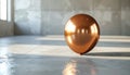 Shiny coppercolored metallic sphere sitting on gray concrete floor in empty room with sunlight reflection Royalty Free Stock Photo