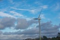 Single large white wind turbine with cloudy blue sky background Royalty Free Stock Photo