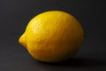 Single lemon isolated on dark black background table. Royalty Free Stock Photo