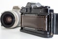 Single lens reflex camera and a film roll on white background Royalty Free Stock Photo