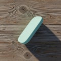 A single light blue rectangular eraser casting a long shadow on a weathered wooden surface isolated on white background Royalty Free Stock Photo