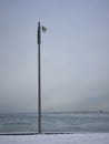 Single light post on beach in winter