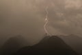 Single lightning bolt strike in mountain peak gray sky