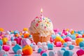 Single Lit Birthday Candle on Vanilla Cupcake with Colorful Sprinkles Surrounded by Pink, Blue, and White Sweet Marshmallows Royalty Free Stock Photo