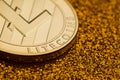 Single litecoin coin on golden glittering background