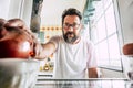 Single lonely man at home adult age looking inside an empty fridge to chooise what to eat - concept of healthy lifestyle and diet Royalty Free Stock Photo