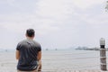 Single lonely man sitting alone looking out to the sea bay. Royalty Free Stock Photo