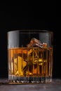 Single malt scotch whiskey in crystal glass with ice cubes on wooden background Royalty Free Stock Photo