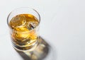 Single malt whiskey in glass with ice cubes with shadow on white Royalty Free Stock Photo