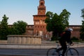 Single man on bicycle riding alone in front of Castello Sforzesc