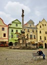 Single man sits on a bench in the center of Cesky Krumlov