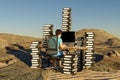 single man sitting at pc office workplace in desert environment with huge stacks of document binders workload stress burnout Royalty Free Stock Photo