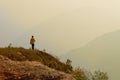 A single man standing at the edge of the cliff and looking at distant Himalayan mountians. Trekking route towards Varsey