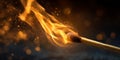 A single match stick igniting with a vibrant orange flame against a blurred dark background Royalty Free Stock Photo