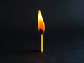 A single matchstick is lit up in the dark Royalty Free Stock Photo