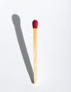 Single Matchstick with a Long Shadow on White Royalty Free Stock Photo