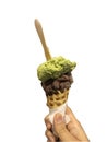 Single melting green and chocolate ice cream scoop flavor in waffle cone in hand holding on white Royalty Free Stock Photo