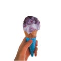 Single melting purple and vanilla ice cream scoop flavor in waffle cone in hand holding on white Royalty Free Stock Photo