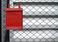 single metal red mailbox hanging on chain link fence Royalty Free Stock Photo