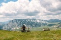 Single millenial man sits on a bench on a mountain plateau and looks at the mountains in front of him. Montenegro, Durmitor