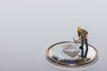 single miner standing on a single silver ether crypto currency with gray