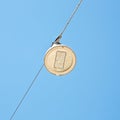 Single modern led street lamp hanging from a metal cable against a clear sky