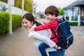 Single mom carrying and playing with her children near home with villa street background. People and Lifestyles concept. Happy