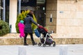 Single mom with child pushing baby stroller in Bucharest, Romania, 2022 Royalty Free Stock Photo