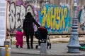 Single mom with child pushing baby stroller in Bucharest, Romania, 2022 Royalty Free Stock Photo