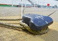 A single mooring device with coiled ropes keeps the ship on the dock.