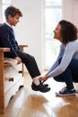 Single Mother At Home Getting Son Wearing Uniform Ready For First Day Of School Royalty Free Stock Photo