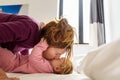 Single mother waking up her baby lying on the bed making gestures of laughter and happiness