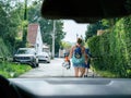 single mother walks along a quaint, narrow street with her two y