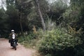 Single motorcycle rider on dirt road in forest