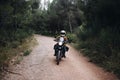 Single motorcycle rider on dirt road in forest Royalty Free Stock Photo